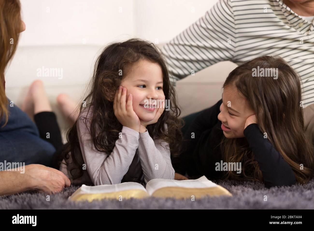 Grandparents teaching grandchildren about the Holy Bible Stock Photo