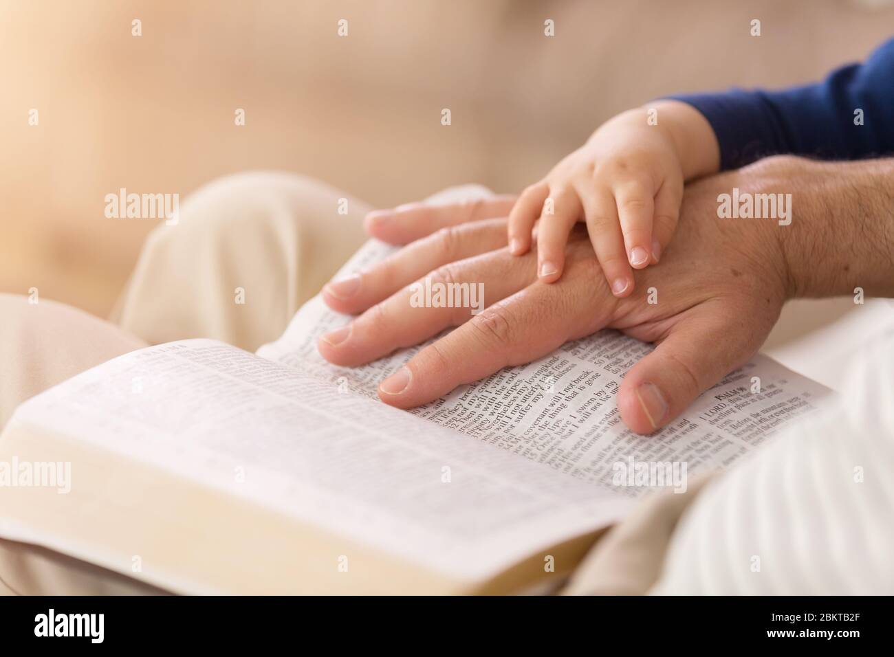 Grandad reading stories from the Holy Bible to his young grandson Stock Photo