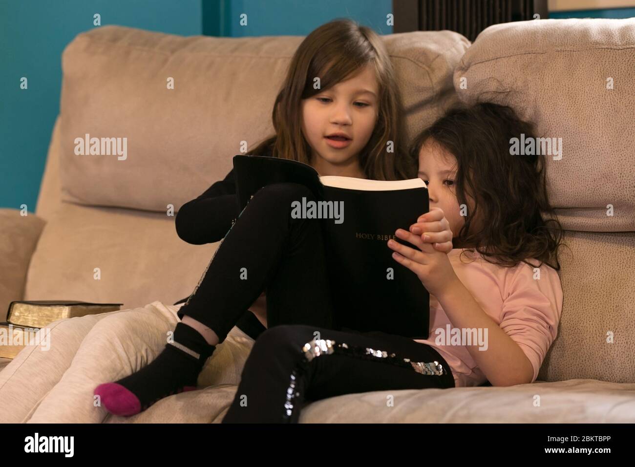 Young sisters reading the Word of God together Stock Photo