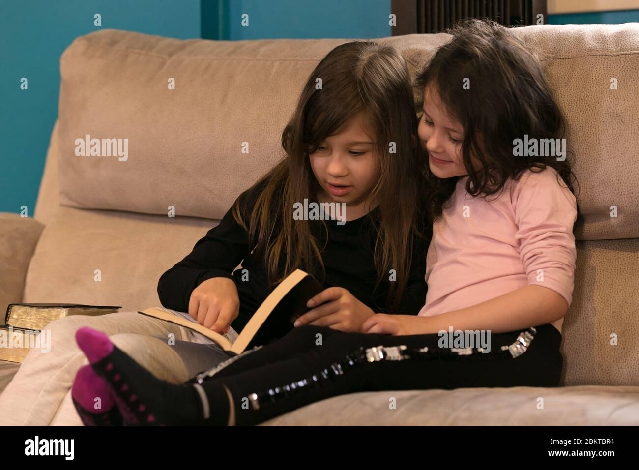 Young sisters reading the Word of God together Stock Photo