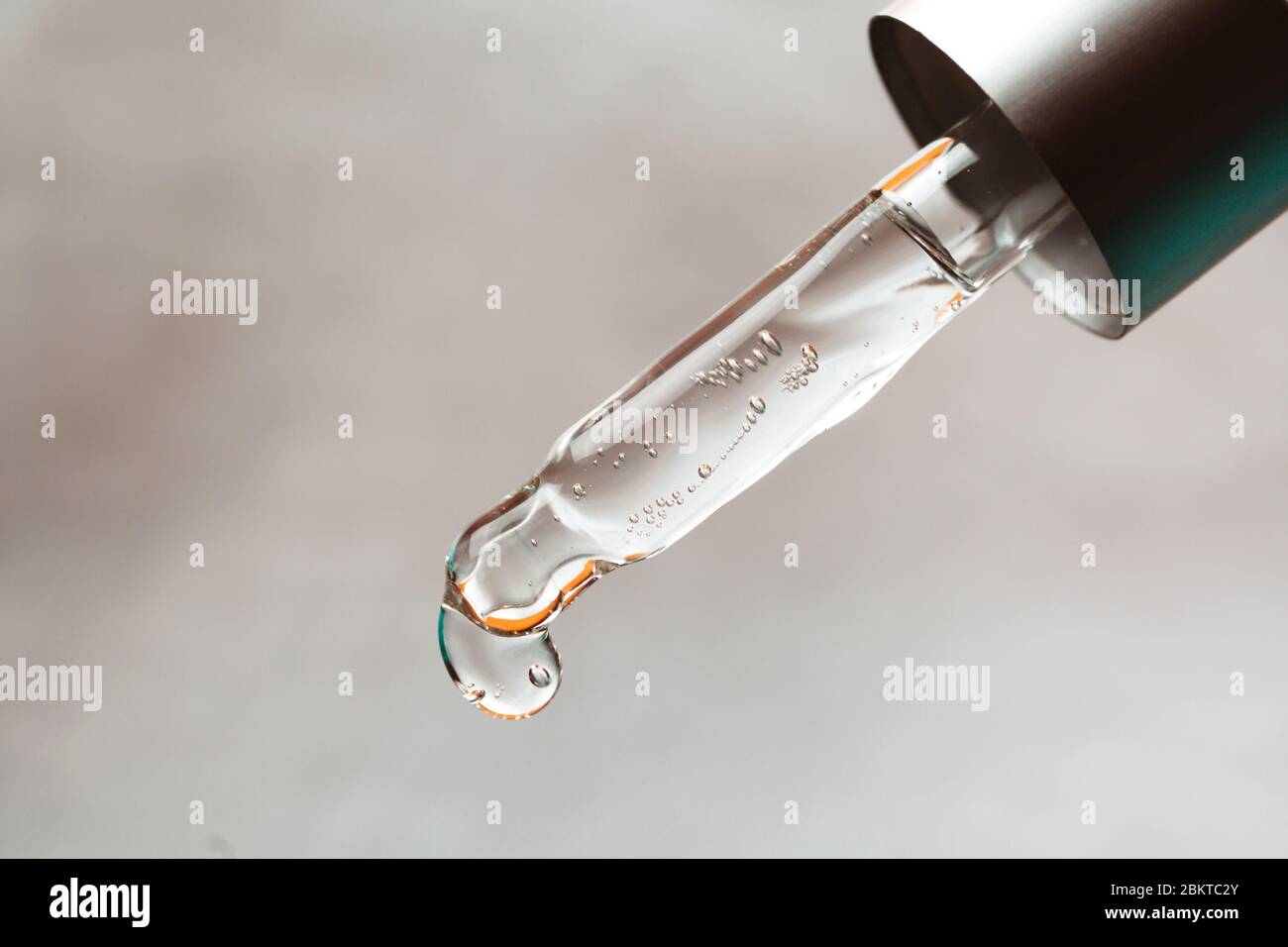 Pipette with drop of hyaluronic acid or serum, macro. Stock Photo