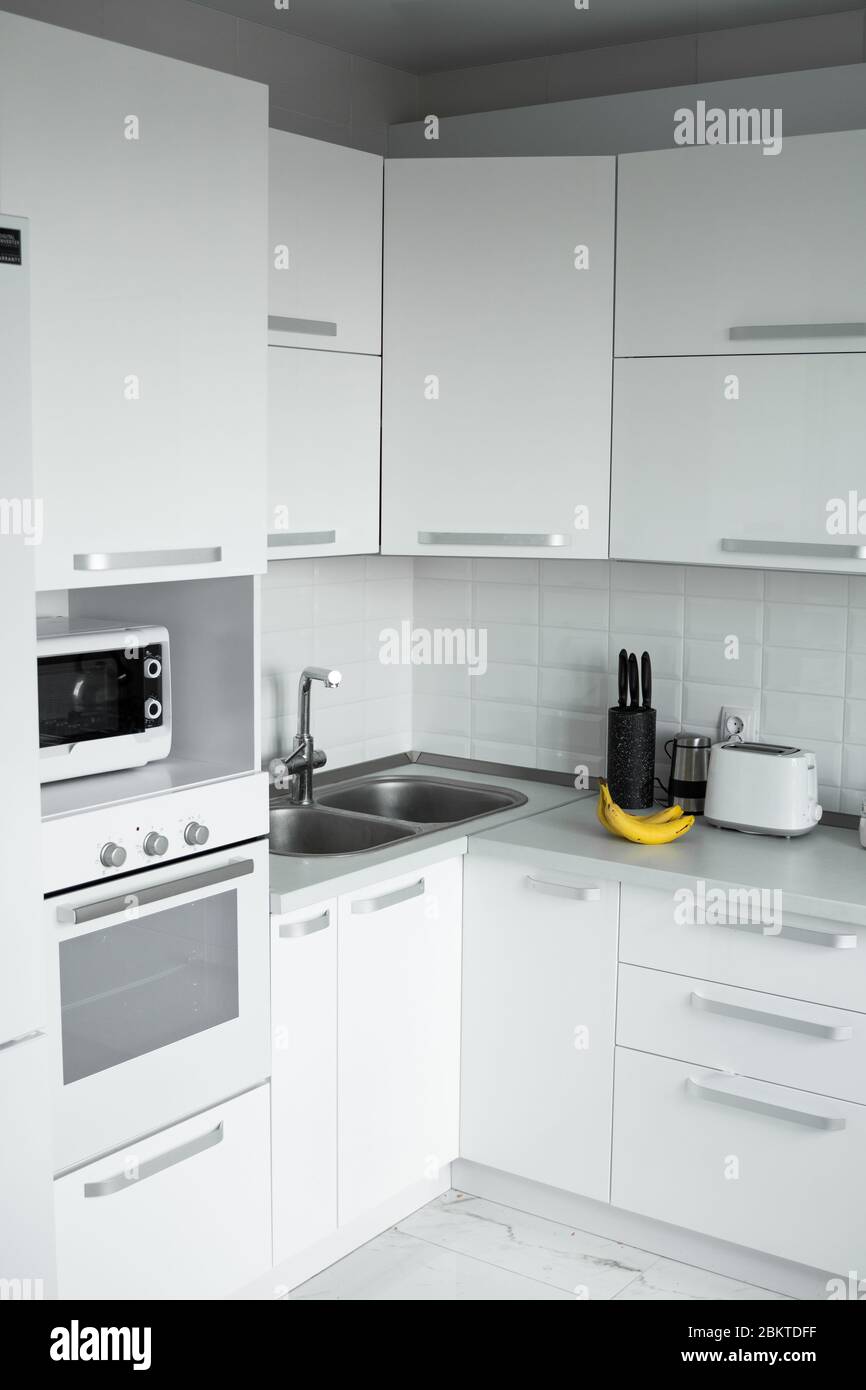 Comfortable White Kitchen With A White Lacquered Facades Modern Kitchen Clean Interior Design Refrigerator Kitchen Oven Microwave Oven And Sink Stock Photo Alamy