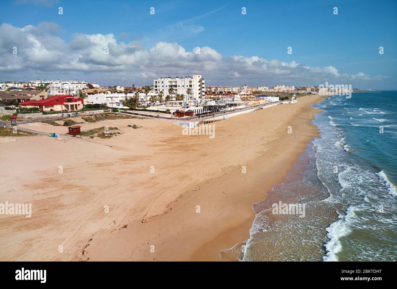 Aerial photography empty sandy coastline of Costa Blanca at sunny day. Mediterranean Sea surf water blue cloudy sky, picturesque scenery Stock Photo