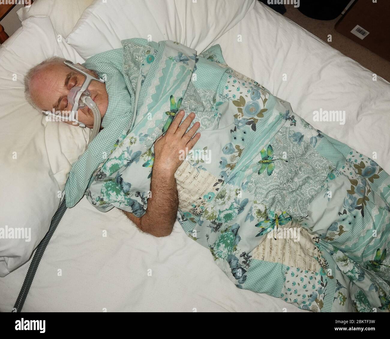 May 2020 - Mature man fast asleep wearing the mask of a CPAP sleep apnea machine @ 03.29am Stock Photo