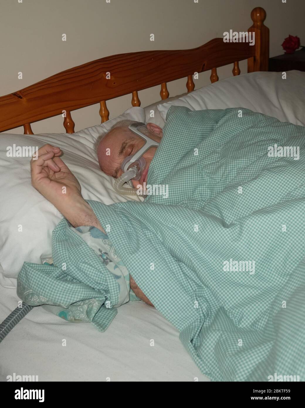 May 2020 - Mature man fast asleep wearing the mask of a CPAP sleep apnea machine @ 04.23am Stock Photo