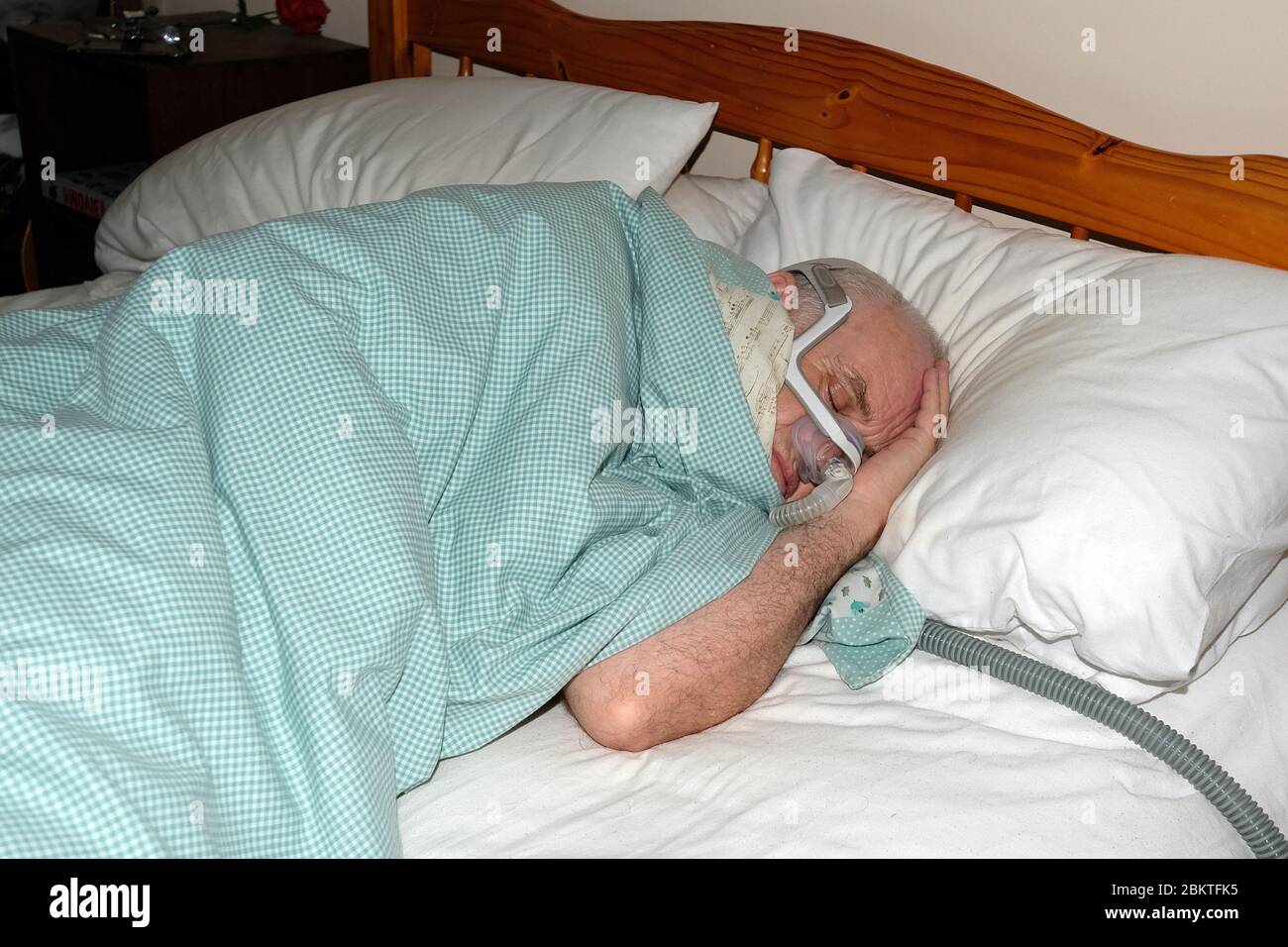 May 2020 - Mature man fast asleep wearing the mask of a CPAP sleep apnea machine @ 3.00AM Stock Photo