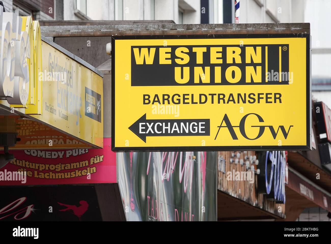 Hamburg, Germany. 03rd May, 2020. A sign with the logo of Western Union  points to a branch of the US provider of worldwide cash transfer on the  Reeperbahn on St. Pauli. Credit: