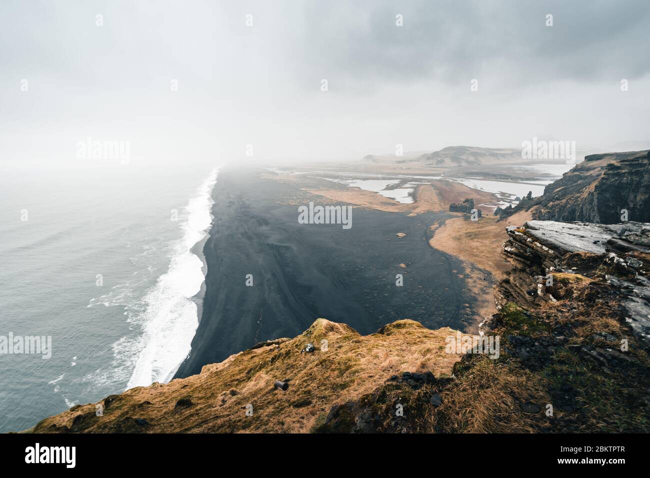 Moody Black Sand Beach in Iceland during the rainy and foggy weather reflects the typical weather conditions of north countries Stock Photo