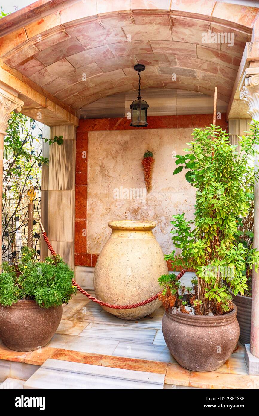 Wine bowl and clay pots with plants near the Cana greek orthodox