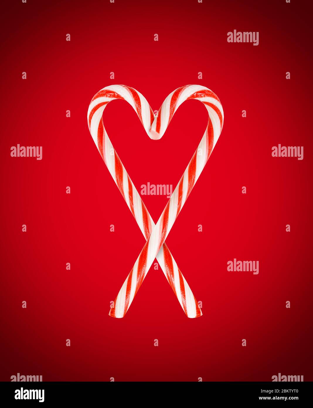 Lollipop Christmas staff on ared background. Red and white striped hard candy cane. Christmas background. Candy shop concept. Christmas candy Stock Photo
