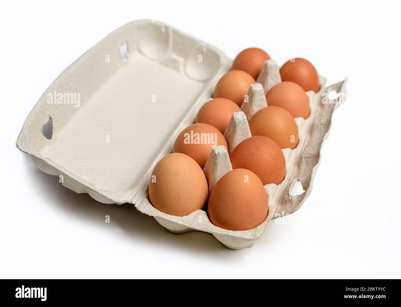 Ten brown eggs in a carton package. Top view. Ten brown eggs in a cardboard box. Eggs. Stock Photo