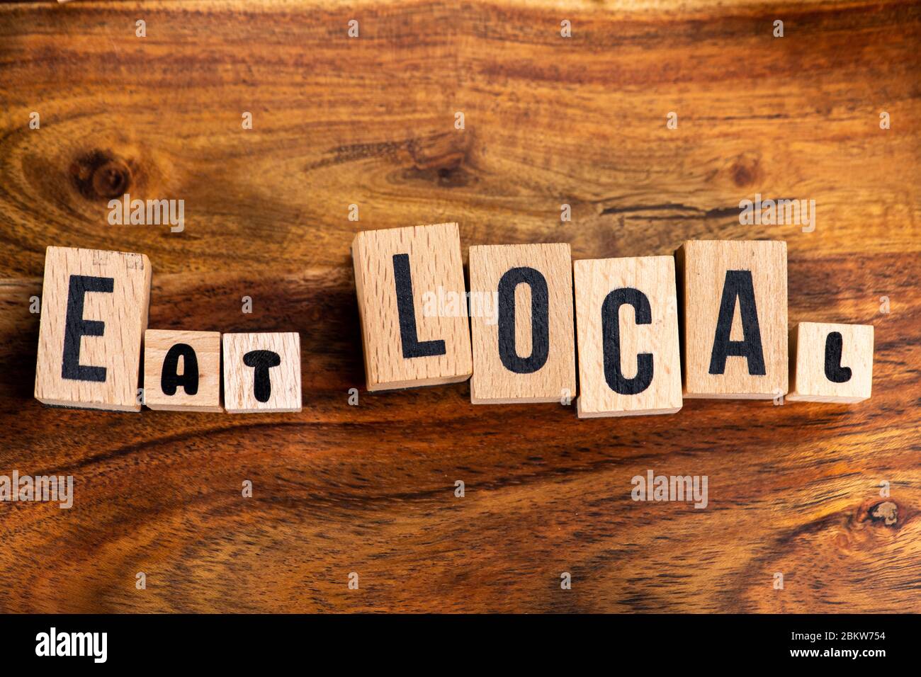 ' EAT LOCAL ' text made of wooden cube on  wooden background. Stock Photo