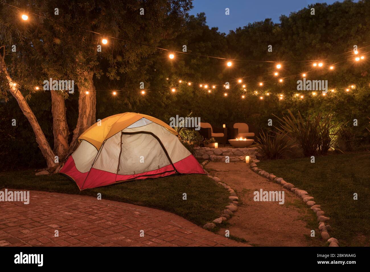 Camping tent in backyard of house at dusk. Stock Photo