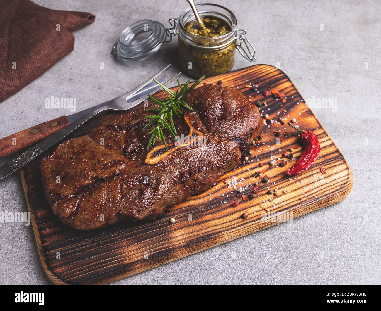 grilled beef steak with bone on a cutting board,  spices Stock Photo