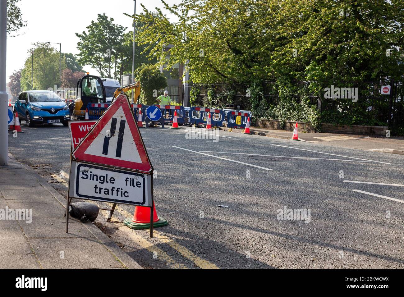 Roadworks on Park Road West, Claughton, Birkenhead. Single file traffic sign and temporary lights. Stock Photo
