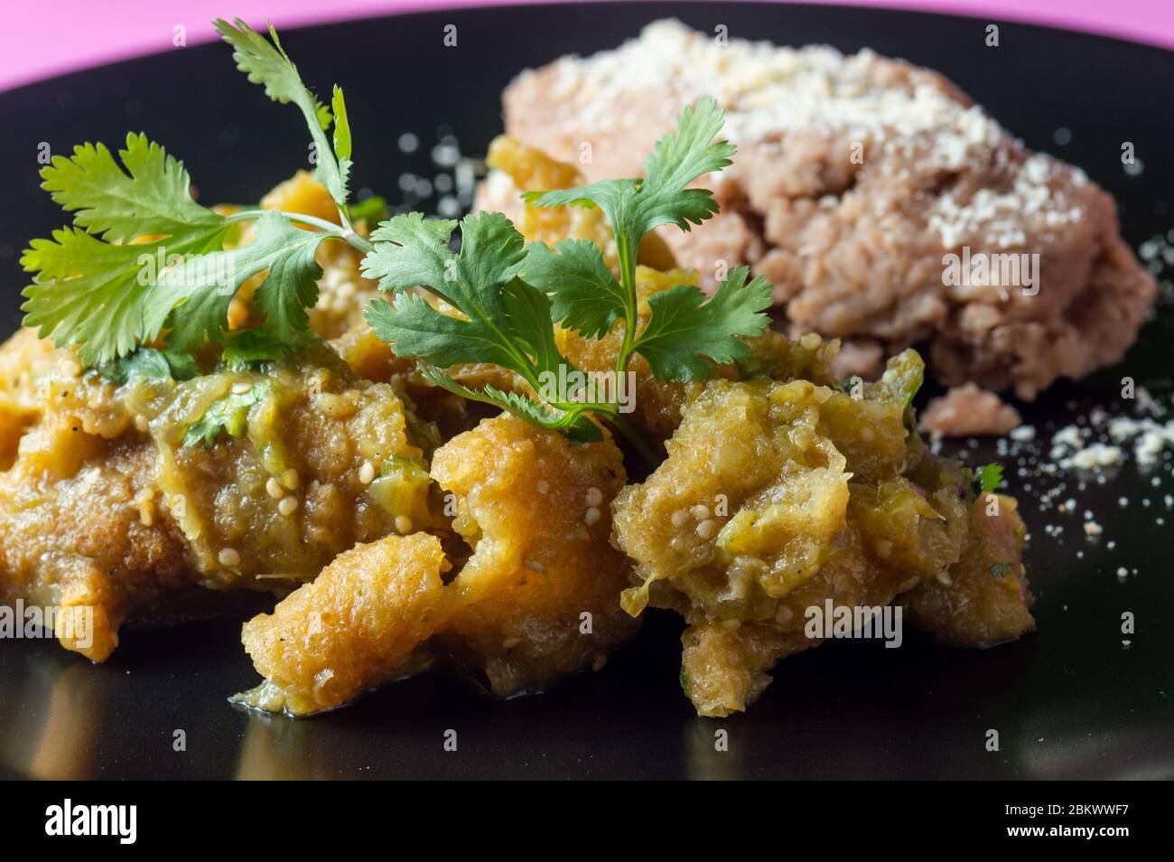 Pork rinds in green salsa with refried beans Stock Photo Alamy