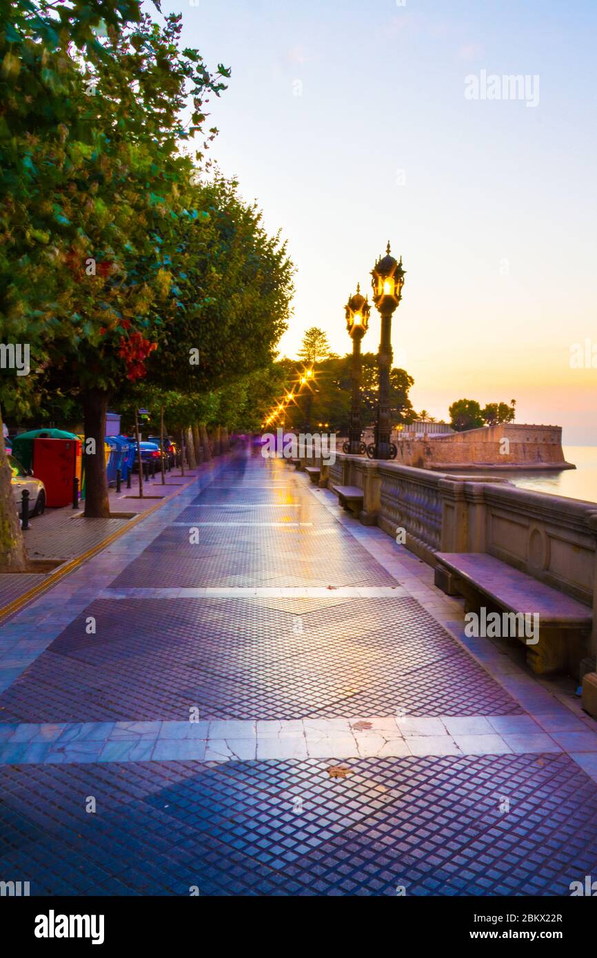 A colorful evening scene in a park in Cadiz, Spain with settle motion blurs of people and starburst in every street light. Stock Photo