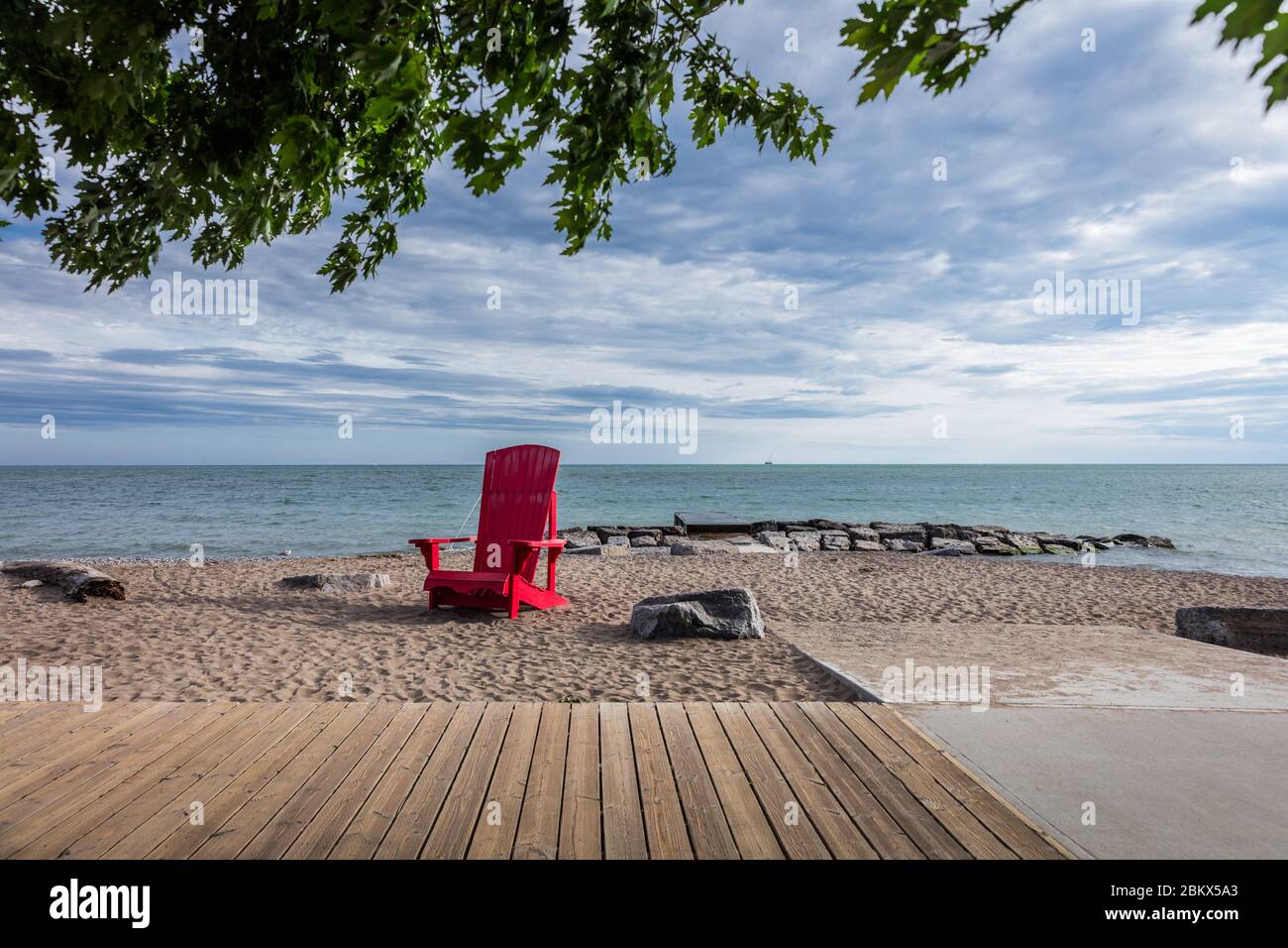 Oversized red Adirondack Chair on city beach in Toronto Canada Stock Photo