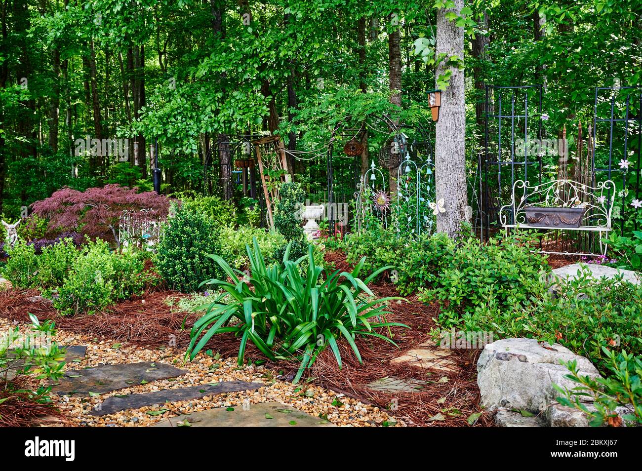 Lush home garden and stone walkway showing beautiful residential landscaping. Stock Photo