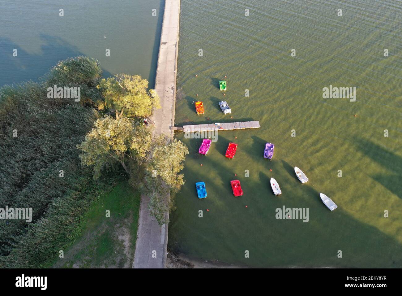 Colorful plastic boats near concrete pier in sea resort, aerial view Stock Photo