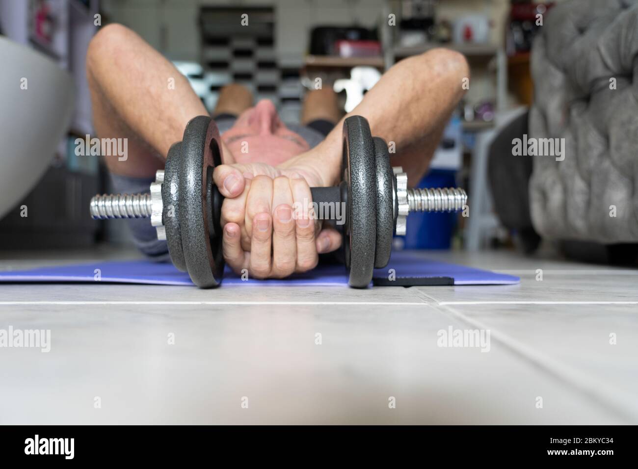 A man undertaking physical fitness exercise within an apartment during the COVID-19 Pandemic 2020. Stock Photo