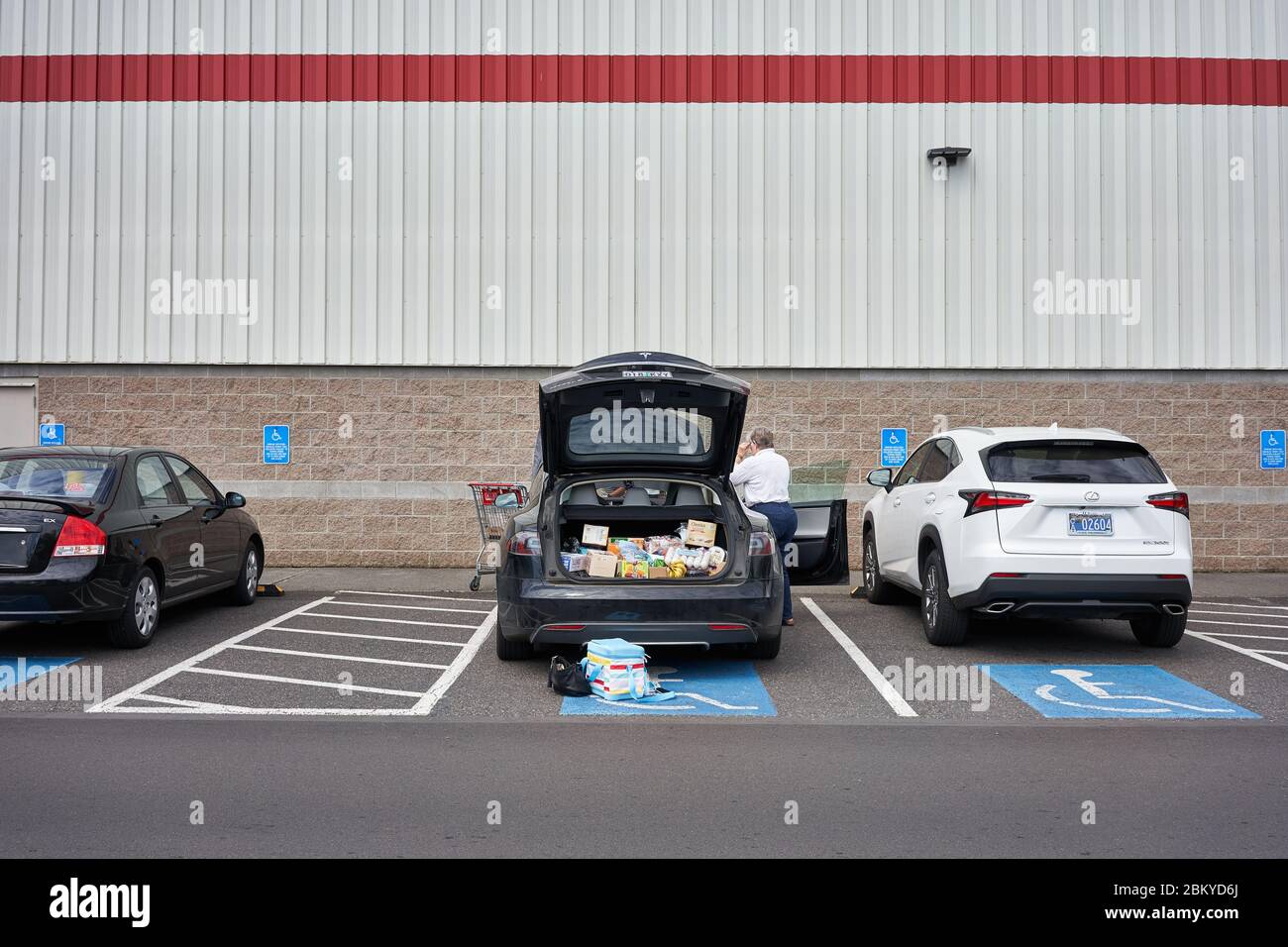 Shoppers load their car after shopping in a Costco warehouse store in Tigard, Oregon, during the coronavirus pandemic, on Tuesday, May 5, 2020. Stock Photo
