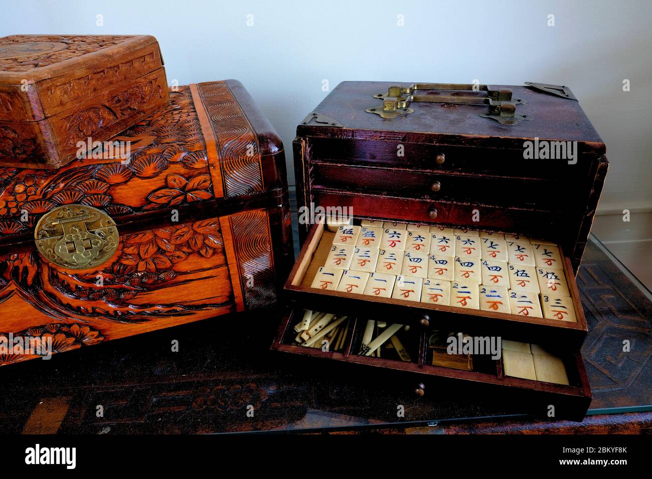 Antique mahjong set with partially open drawers exposing white tiles with Chinese characters, counters, and game pieces; mah-jong, mah-jongg. Stock Photo