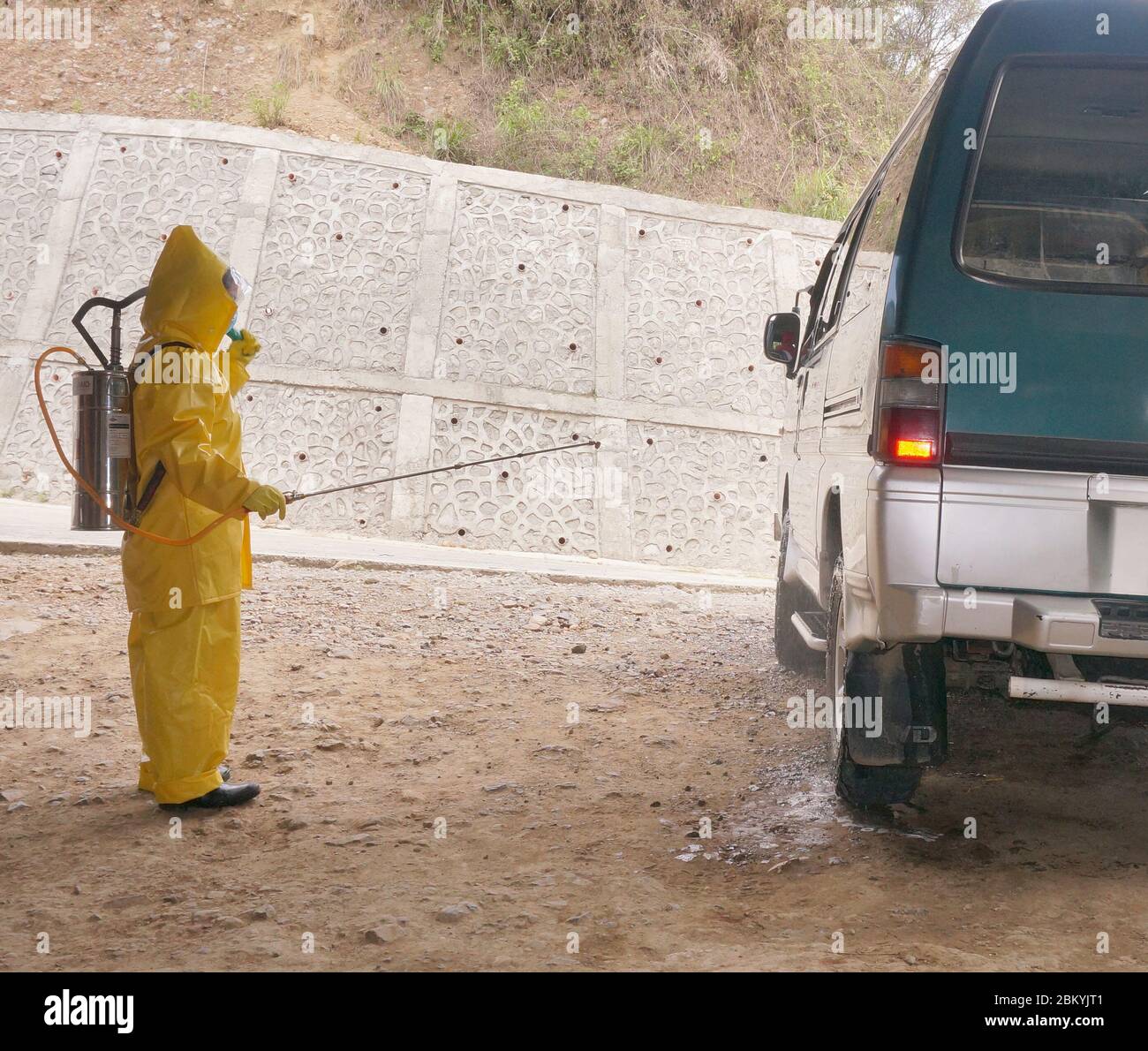 A personnel spraying disinfectant on van, one of the procedures to contain or avoid the spread of corona virus or COVID-19. (Philippines May 6, 2020). Stock Photo