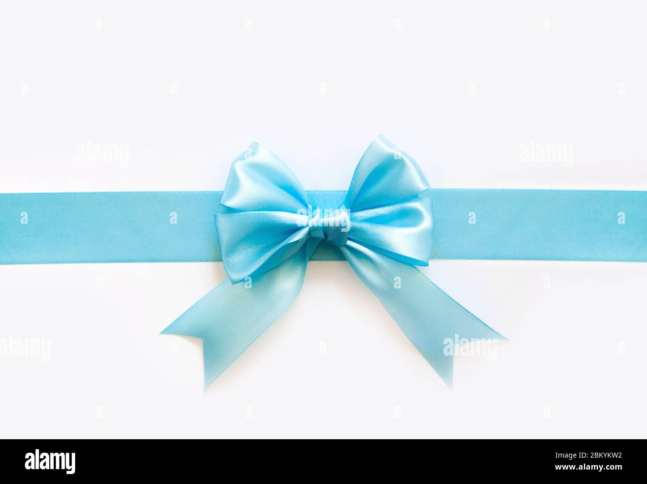 Blue wide satin ribbon with a bow. White background Stock Photo - Alamy