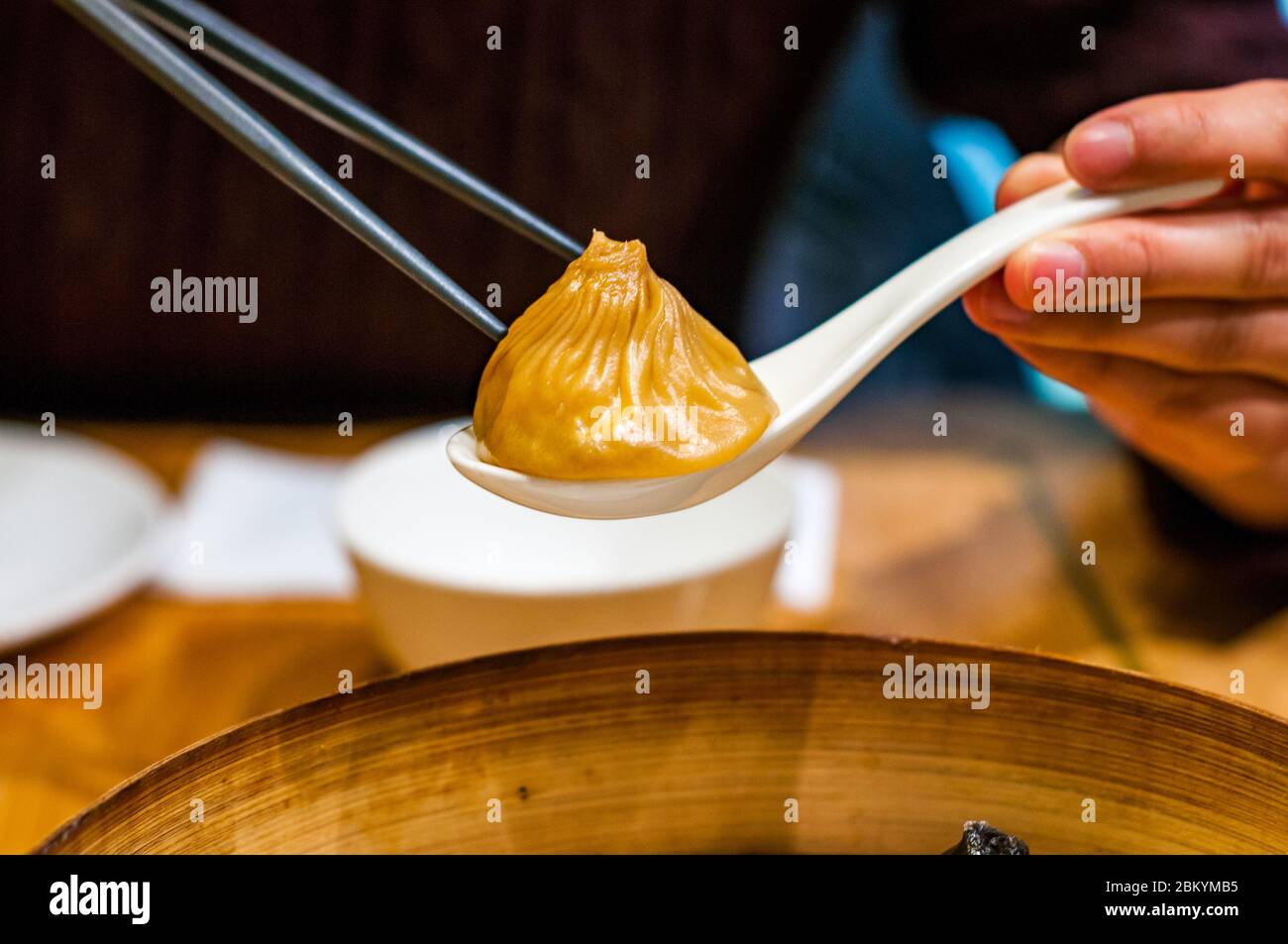A Chinese lady picks up a foie gras flavoured gourmet xiaolongbao soup
