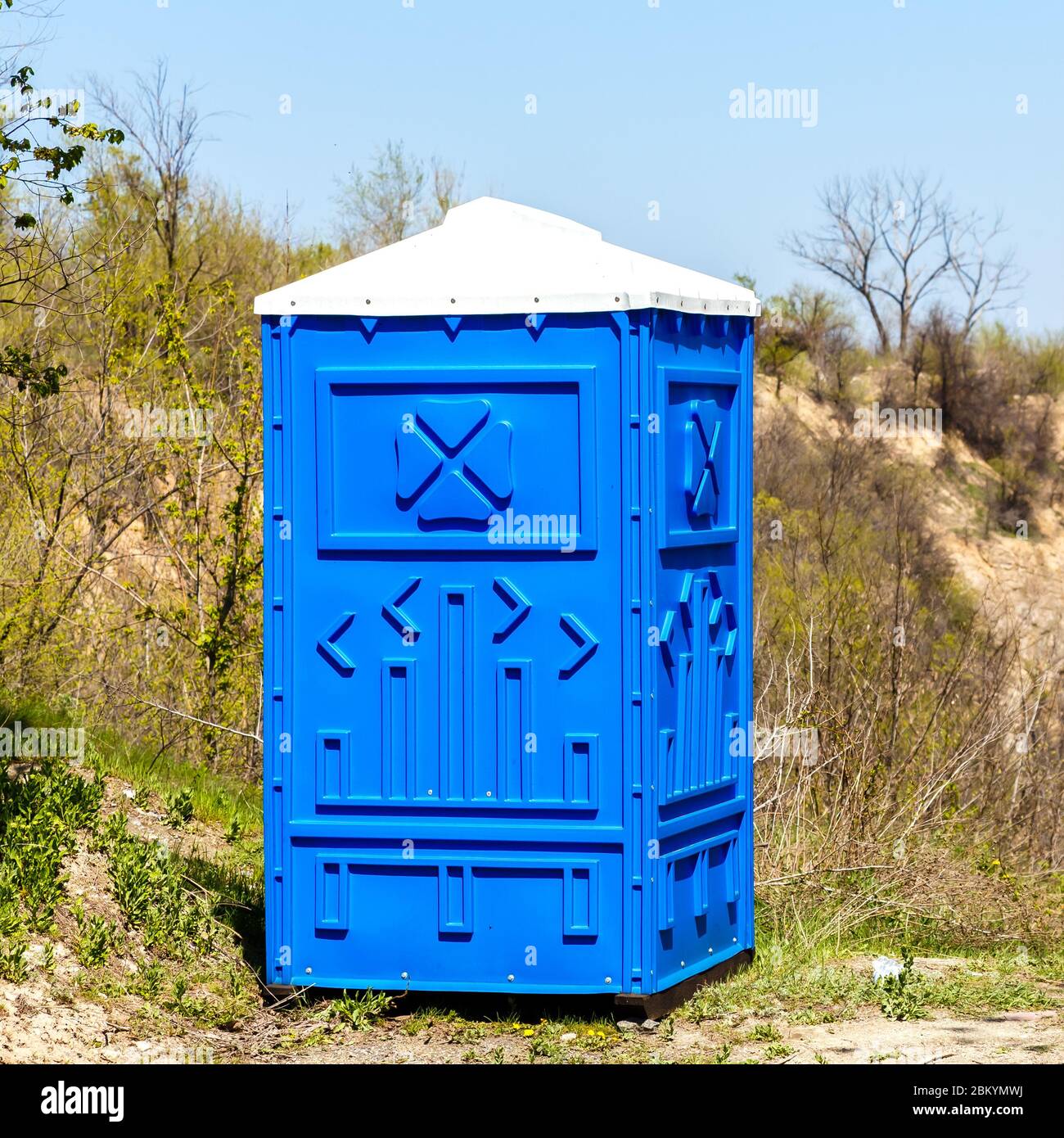 Blue Cabine Of Chemical Toilet In a Mountain Park at sunny Summer Day. Stock Photo