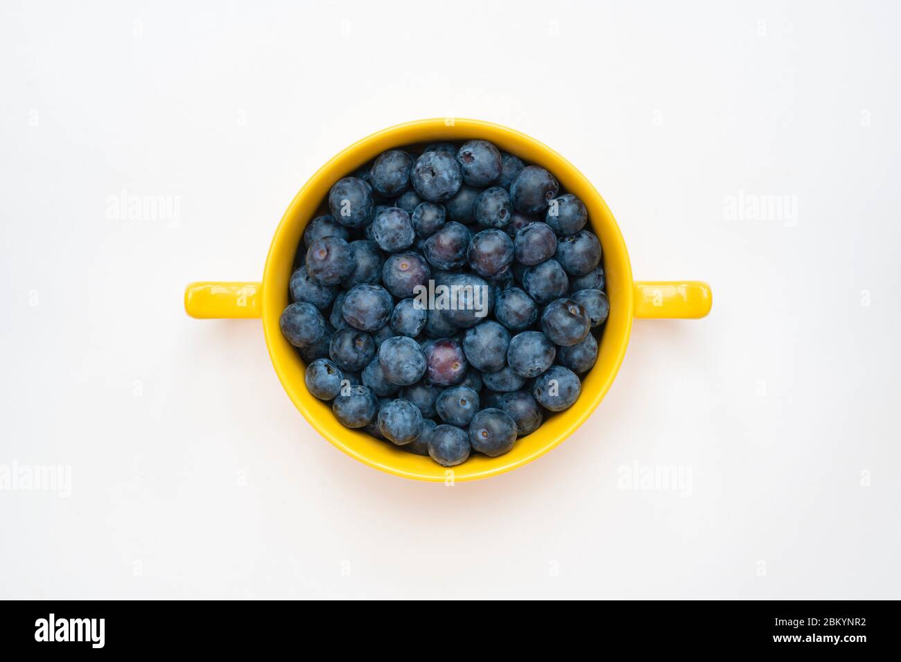 Vaccinium corymbosum. Blueberries in a yellow bowl on a white background Stock Photo