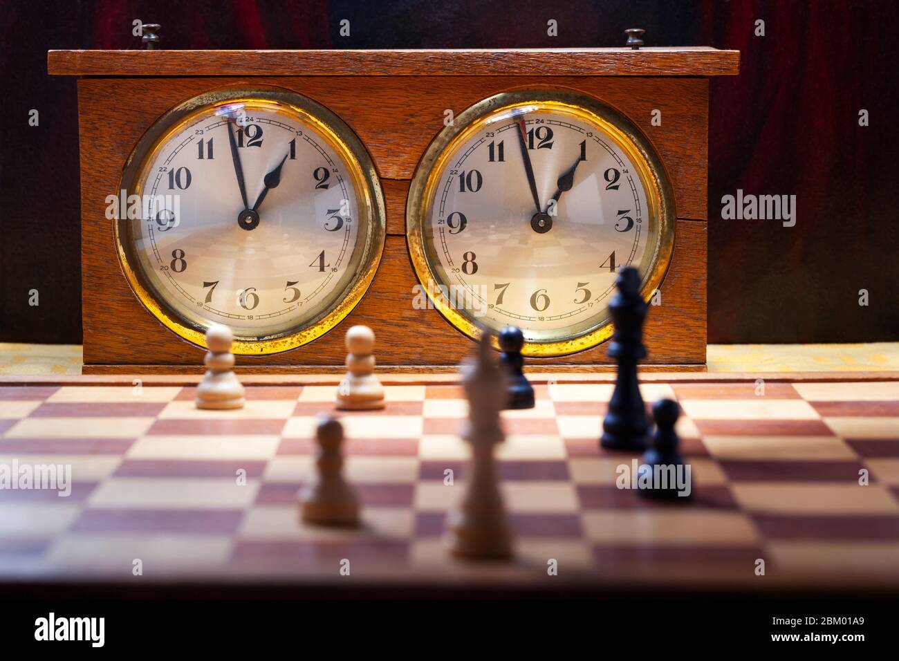 Old wooden vintage chess clock with an endgame on chessboard Stock Photo