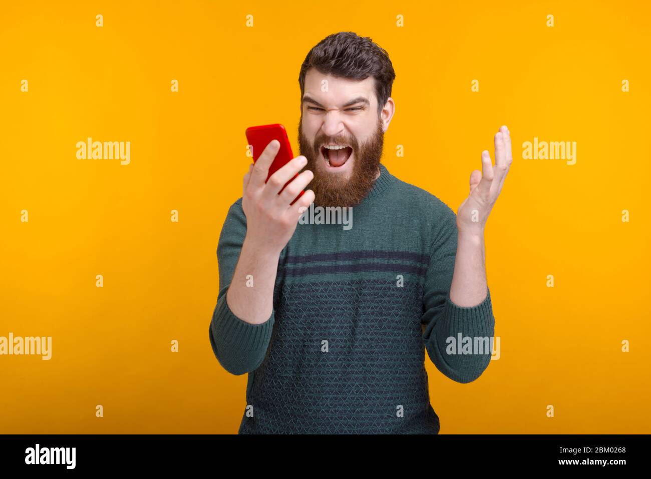 Crazy man is shouting at his phone because it isnt working over yellow