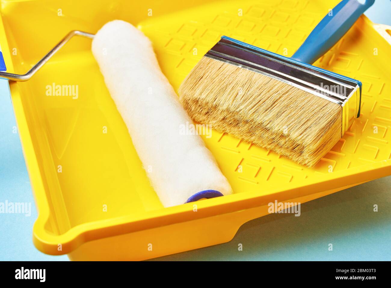 plastic yellow bath with brushes and a roller for painting and repair ...