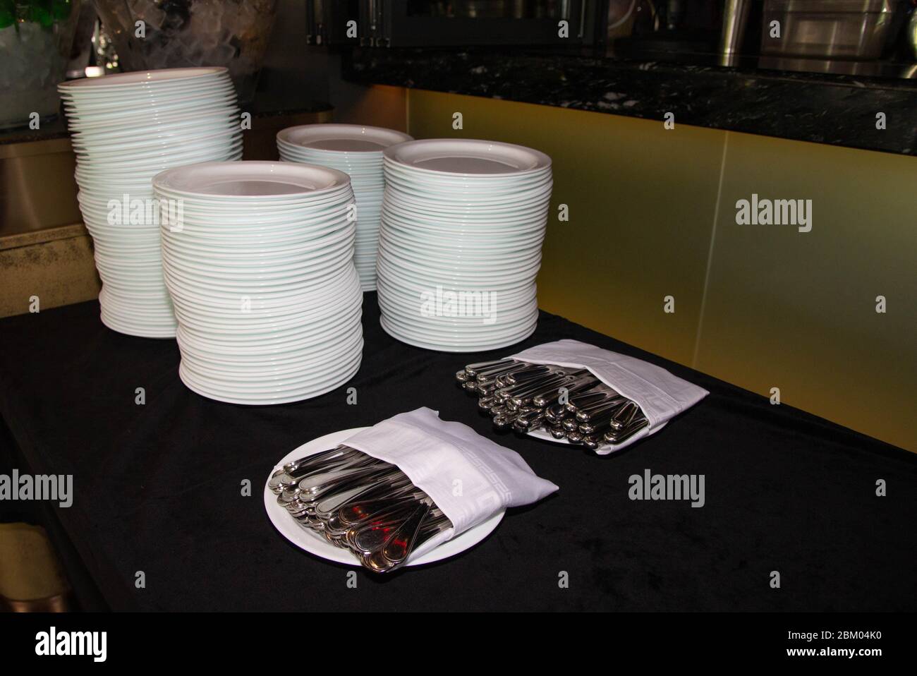 Stacked of plates,spoon,fork,knives on a buffet restaurant Stock Photo