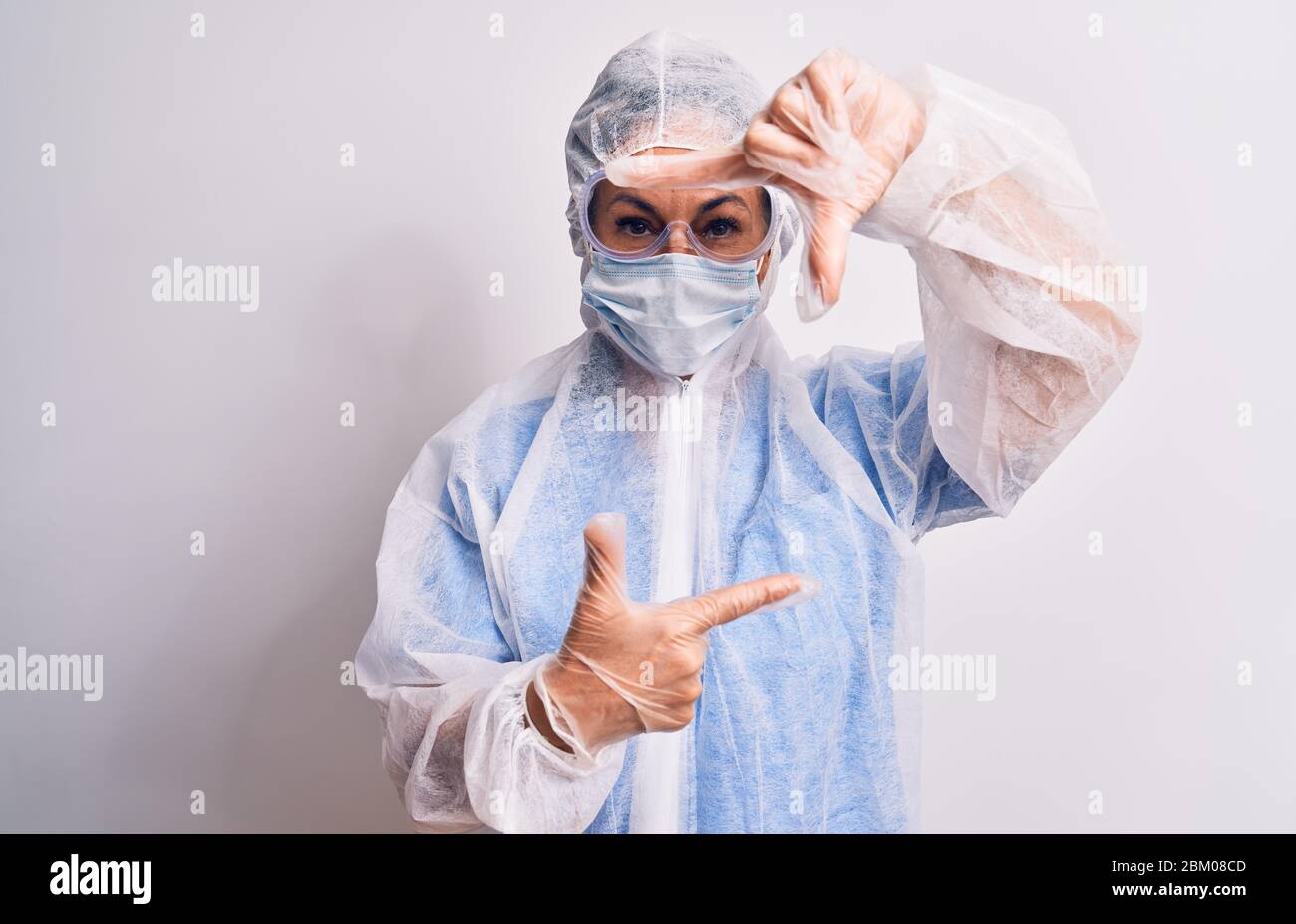 Middle age nurse woman wearing protection coronavirus equipment over ...