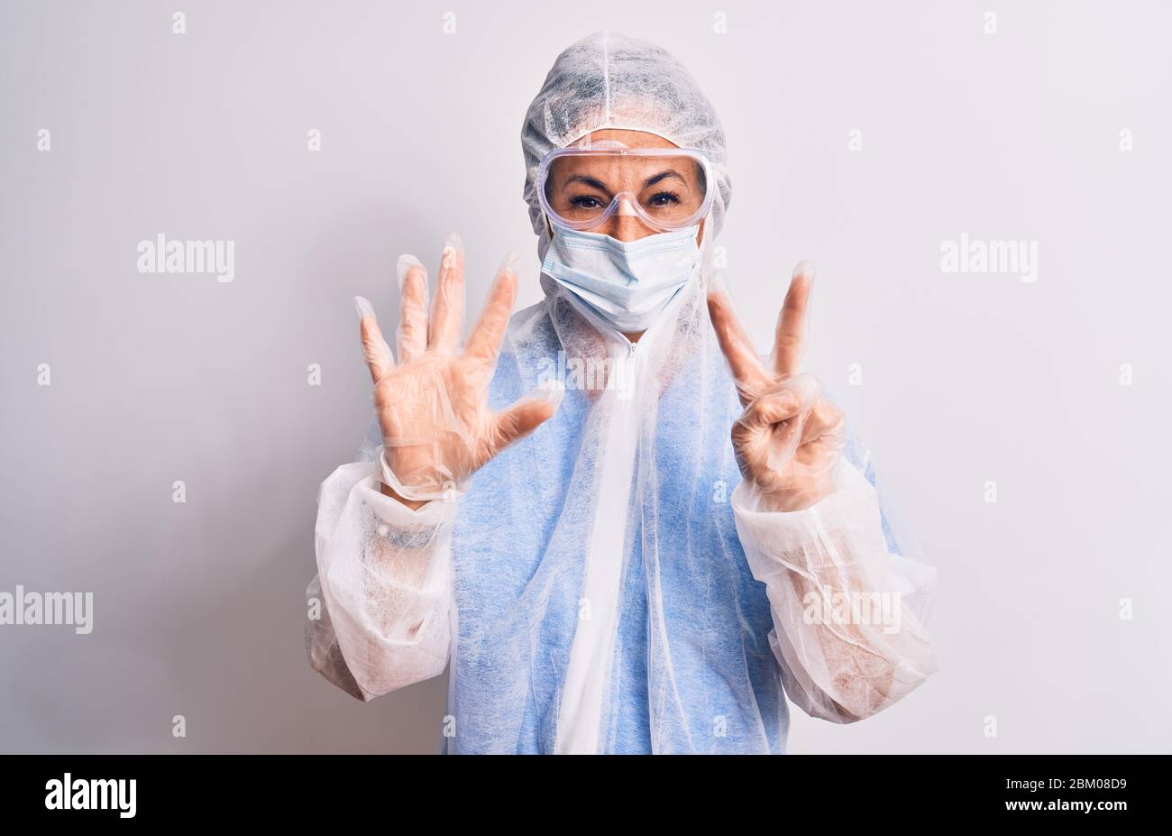 Middle age nurse woman wearing protection coronavirus equipment over ...
