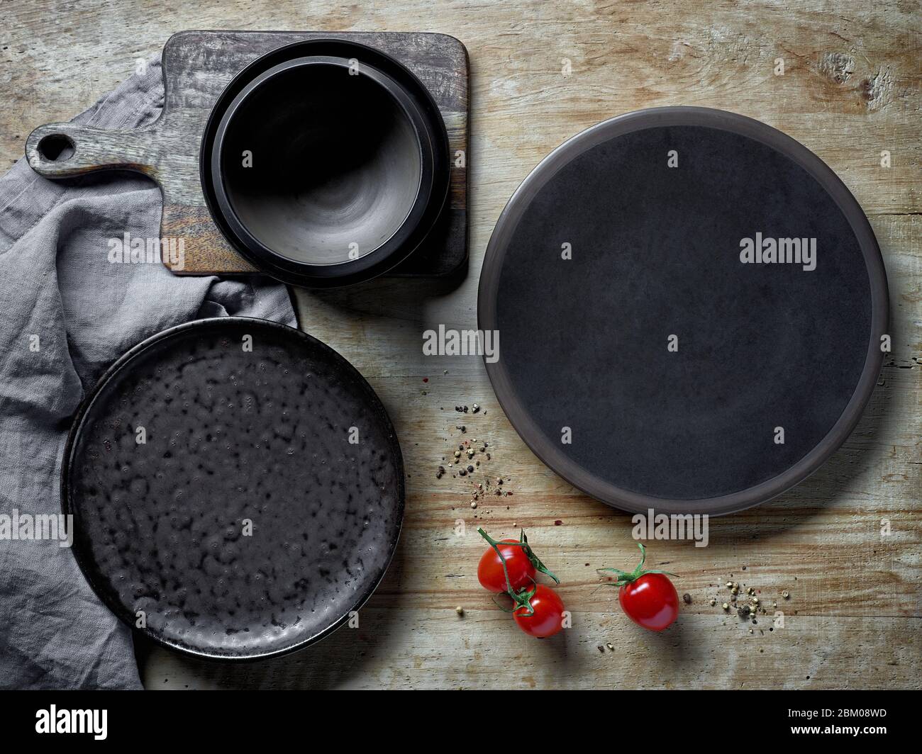 various empty dark plates on rustic wooden table, top view Stock Photo