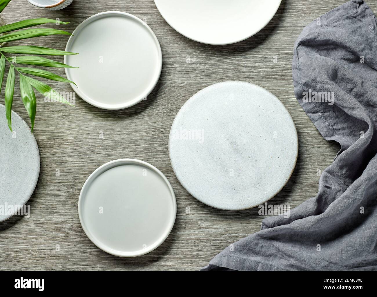 various empty white plates on grey wooden table, top view Stock Photo