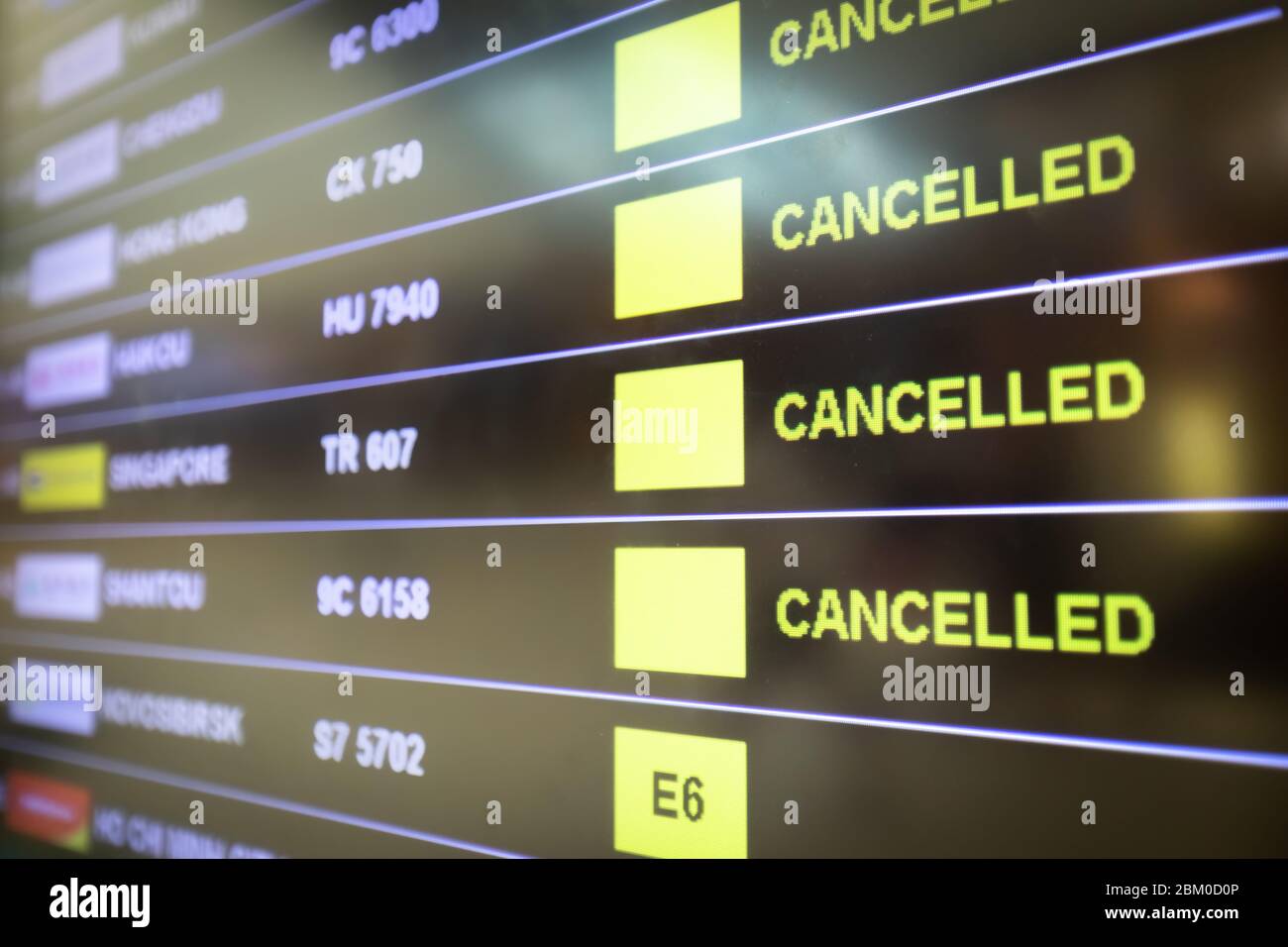 Flights cancelled and delayed on airport departure board due to covid-19 pandemic. Coronavirus causing disruption in air transport with airlines cance Stock Photo