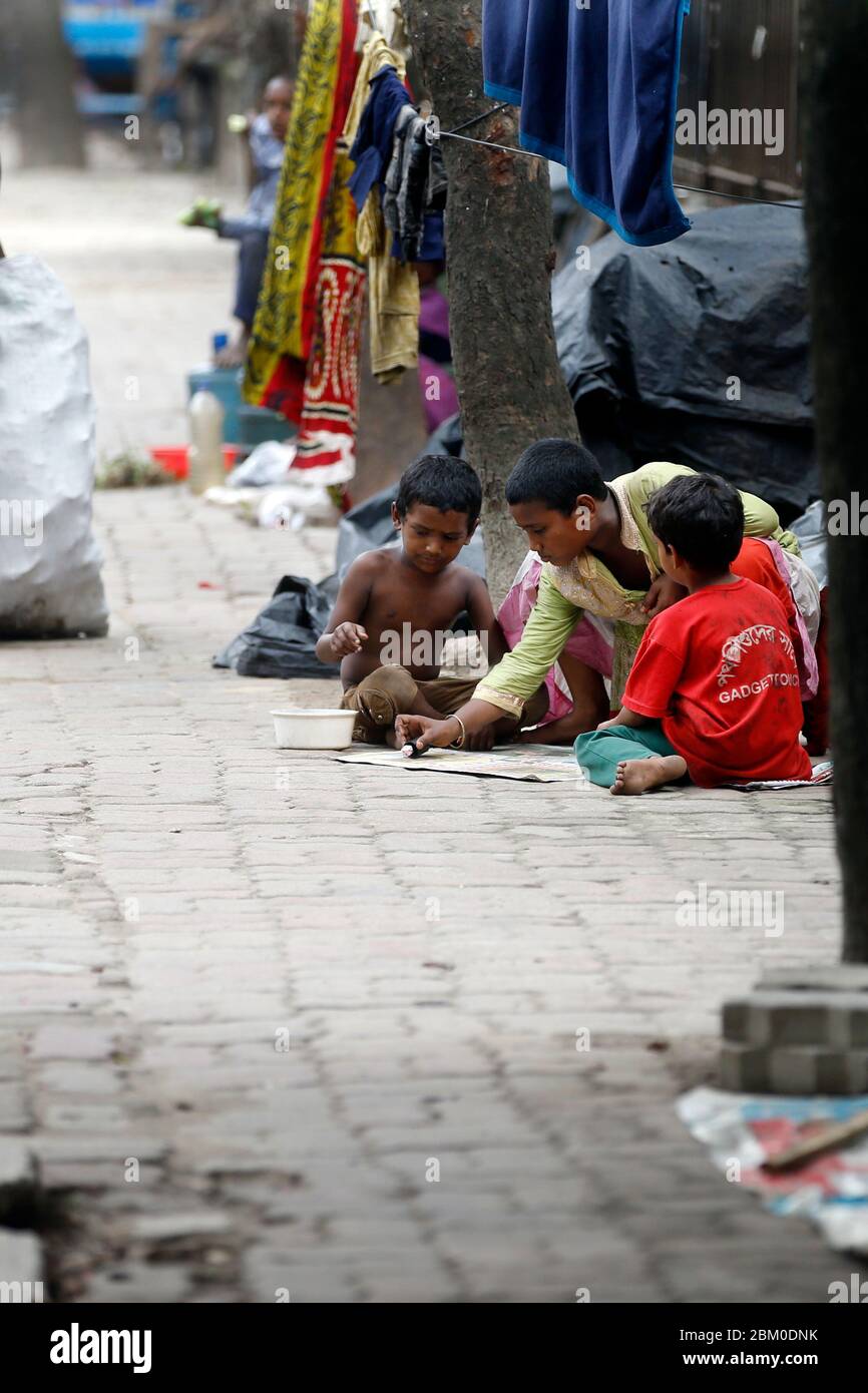 Homeless children who live on footpath playing ludo, Ludo is a strategy board game for two to four players, as as Government call a fifth time increas Stock Photo