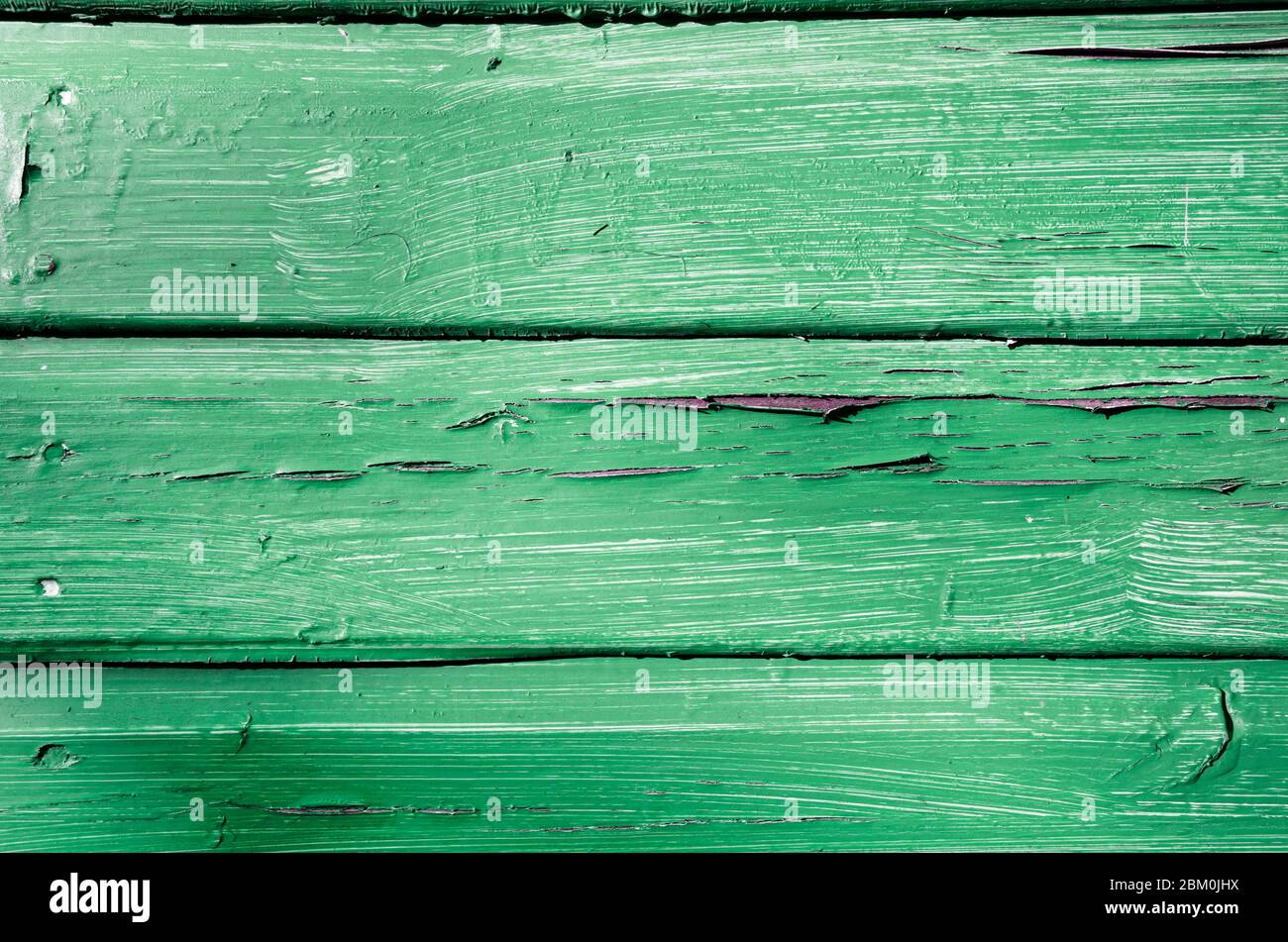Close up of peeling paint against green faded rotting wooden panels Stock Photo