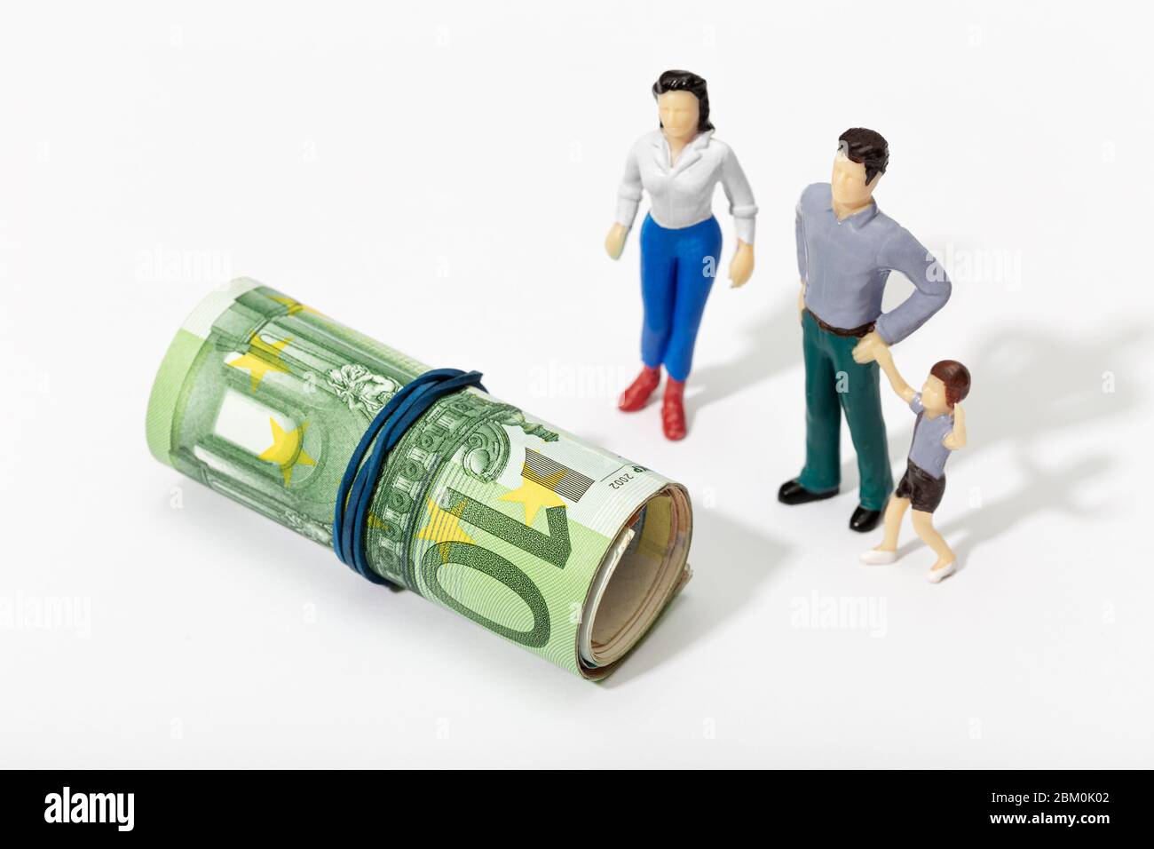 Human representation of a family looking at a Roll of money. Finance, investment or savings concept Stock Photo