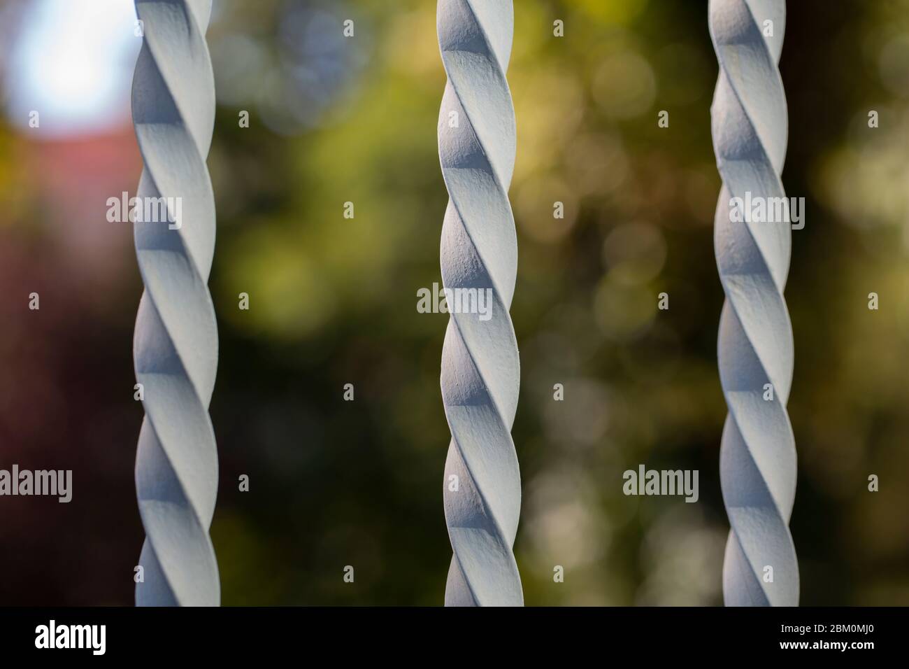 Three spiral rods of a fence with a blurry background Stock Photo