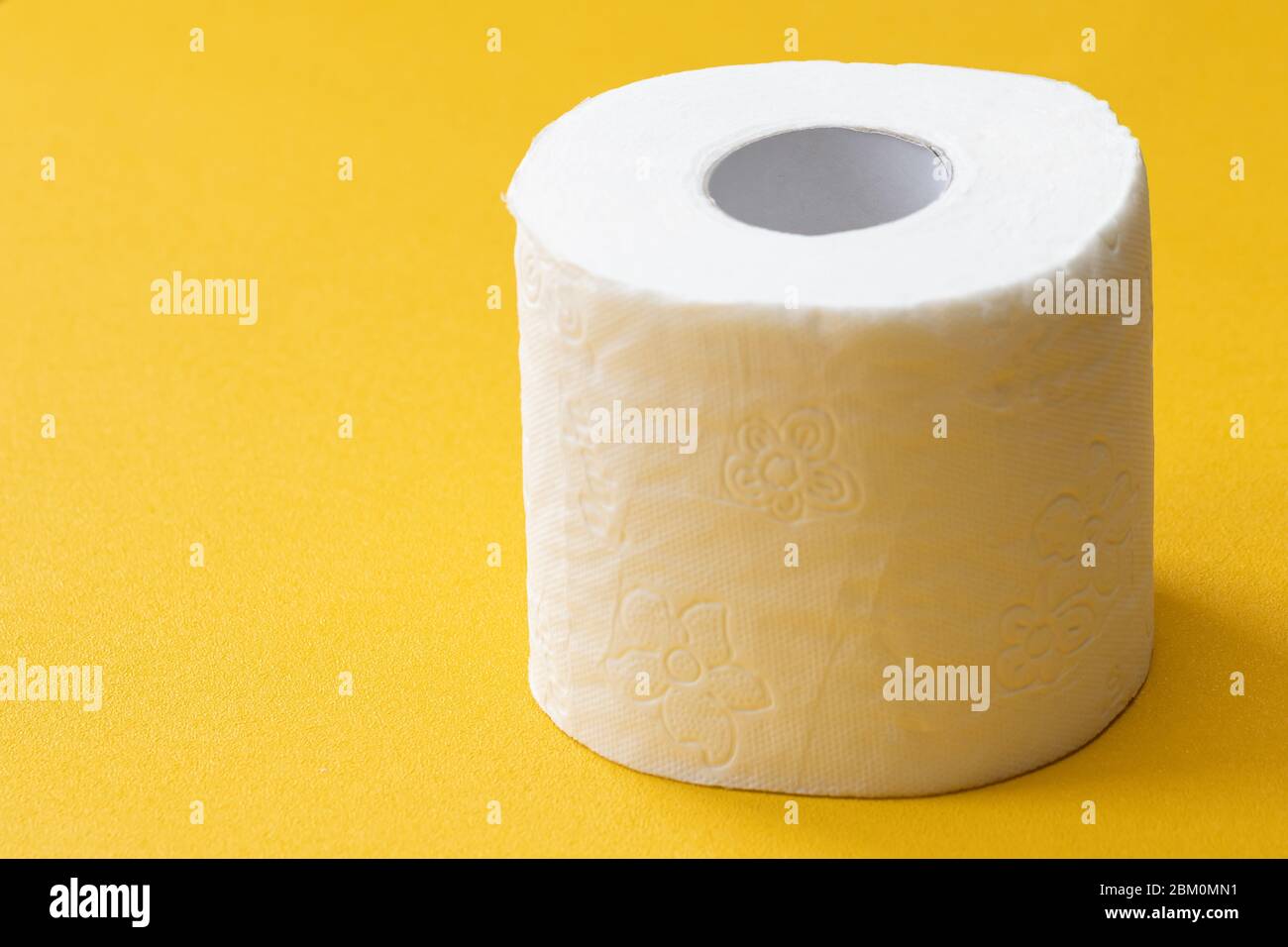 Close-up image of toilet roll isolated on yellow background, copy space for your design or text Stock Photo
