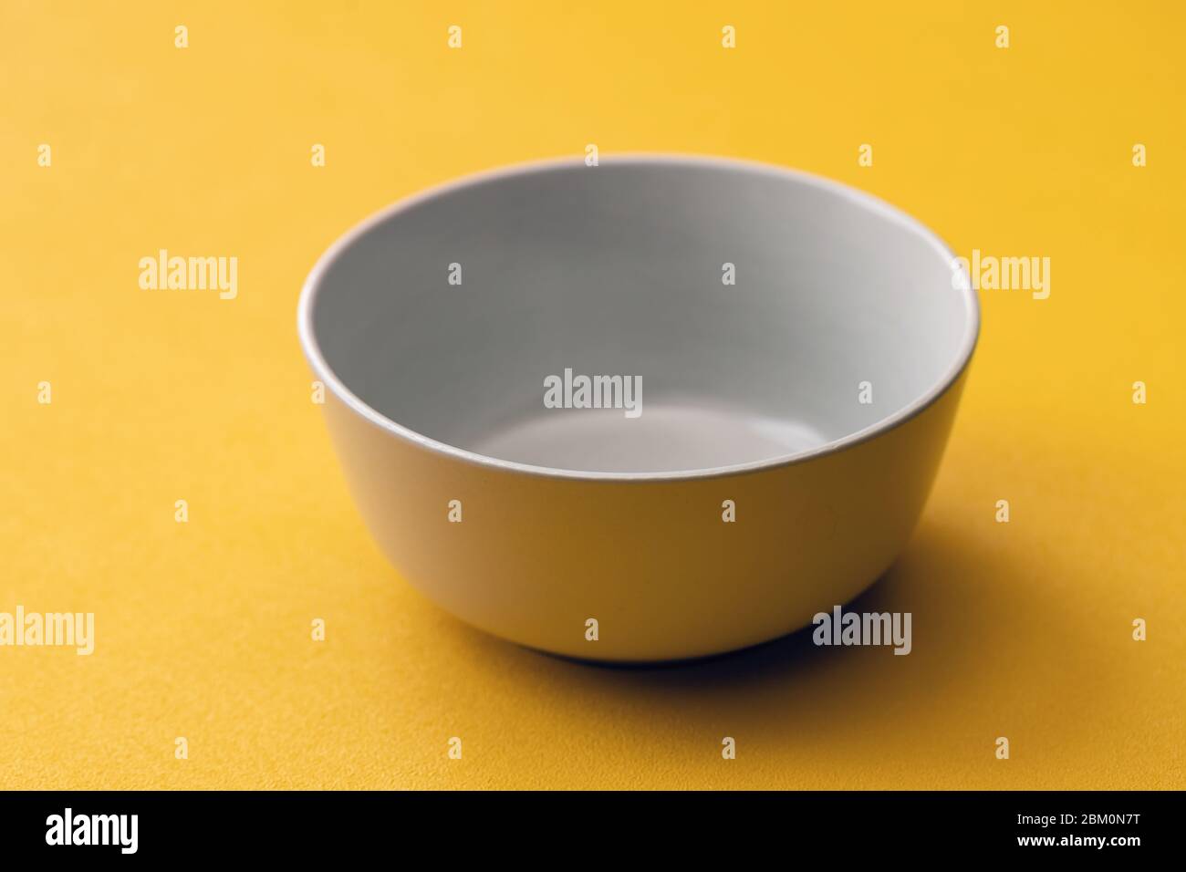 Empty white Cup on a yellow background, isolate. Stock Photo