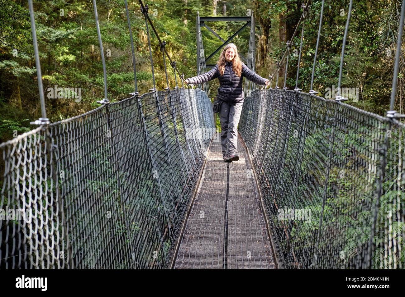 Woman crossing a suspension bridge over a stream on the Kepler track Stock  Photo - Alamy