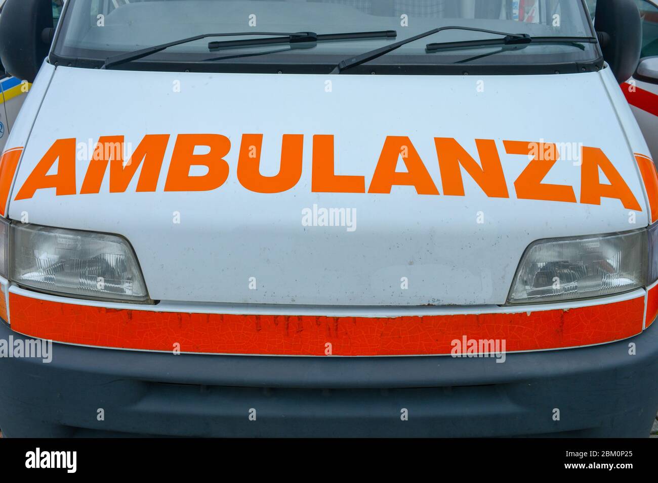 An italian ambulance car. Closeup of front of an ambo vehicle carring paramedics for emergency situations and patients in need. Orange words Stock Photo