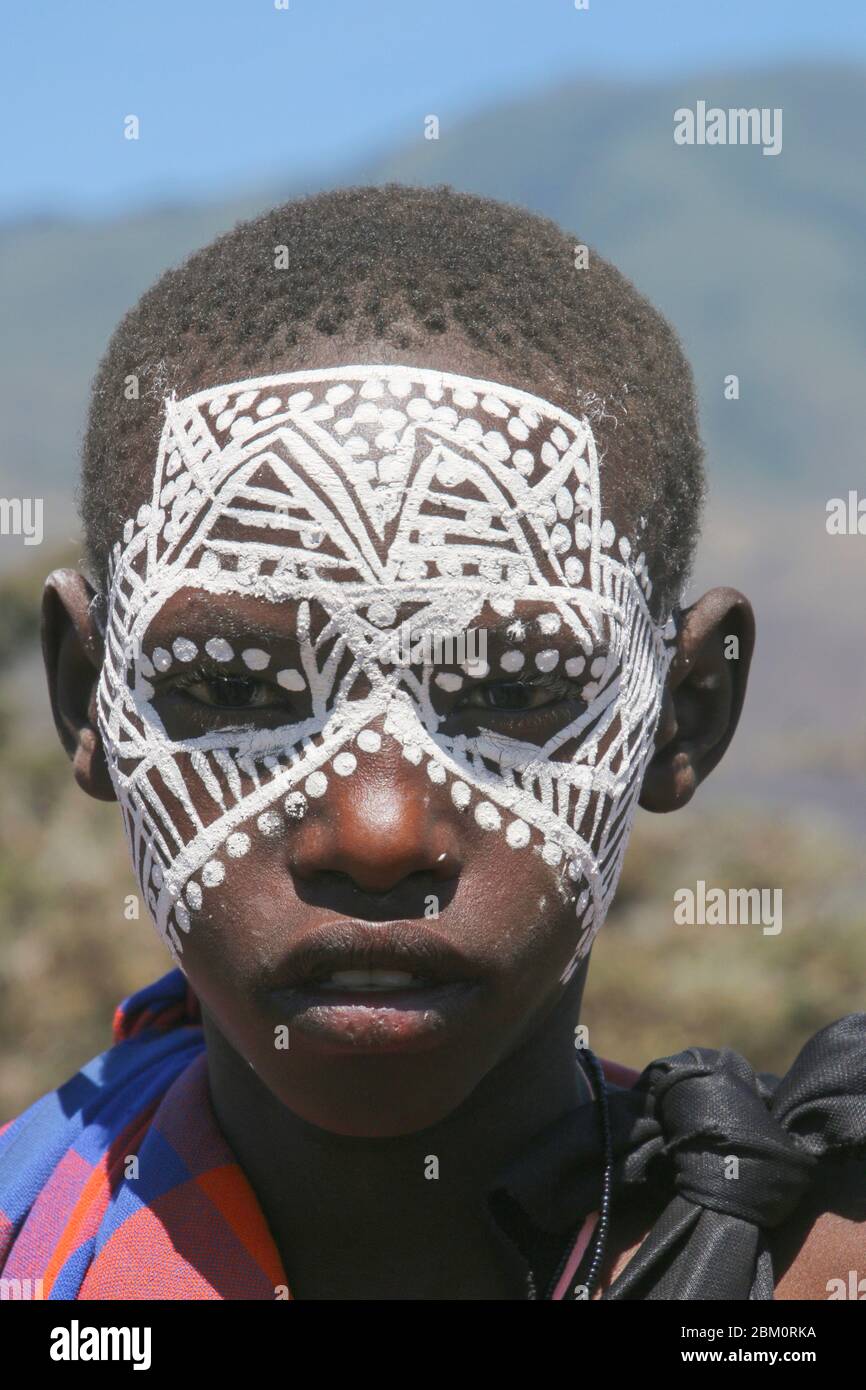 A teenage Maasai with painted face after the 'emorata' ceremony, which is the circumcision and right of passage to become a member of the warrior or ' Stock Photo